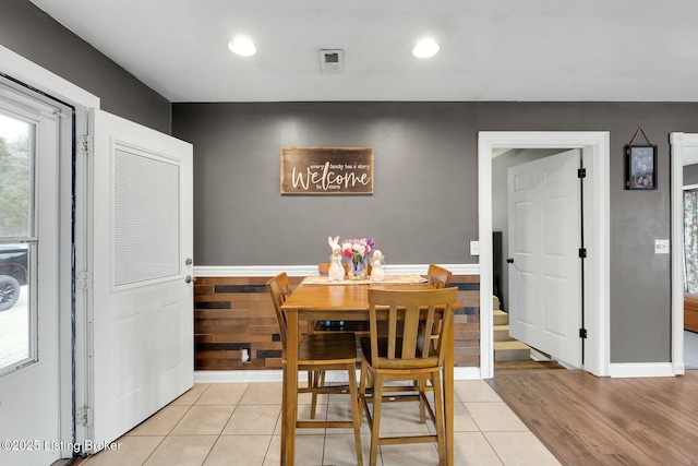 dining area with a wainscoted wall, light tile patterned floors, and recessed lighting