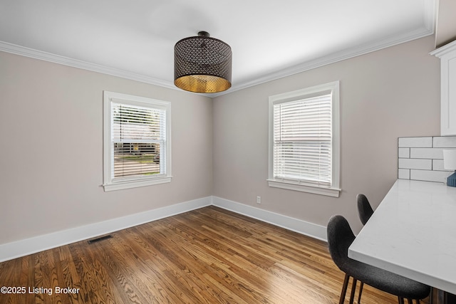 office area featuring ornamental molding, visible vents, and wood finished floors