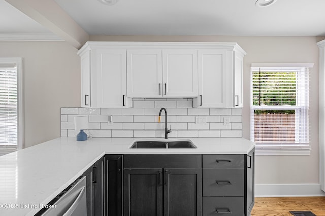 kitchen with light countertops, a sink, and decorative backsplash