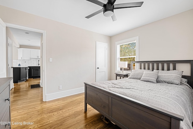bedroom featuring baseboards, a ceiling fan, and light wood-style floors