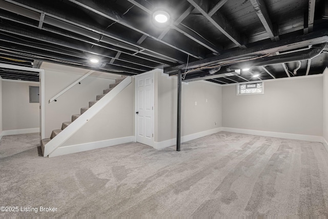 basement featuring electric panel, stairs, carpet, and baseboards