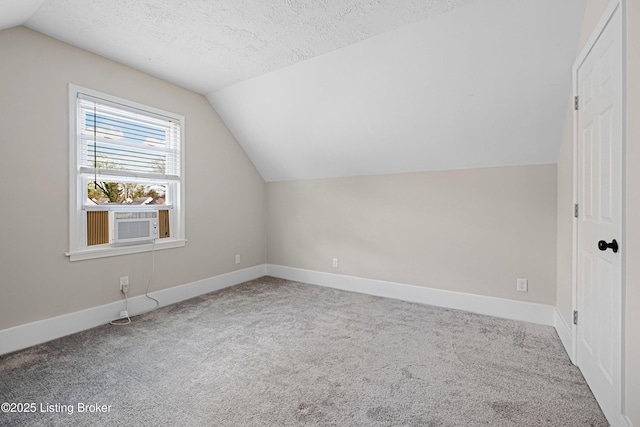 bonus room featuring baseboards, carpet flooring, a textured ceiling, and vaulted ceiling