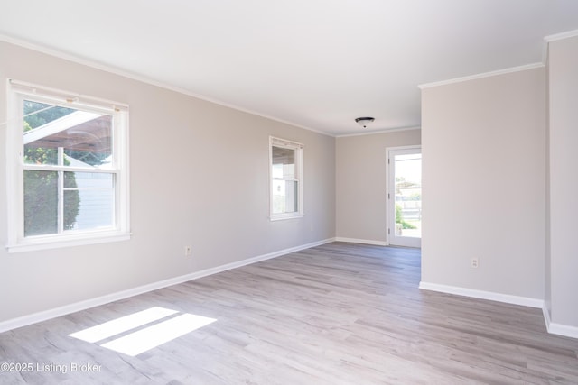 unfurnished room with ornamental molding, light wood-style floors, and baseboards