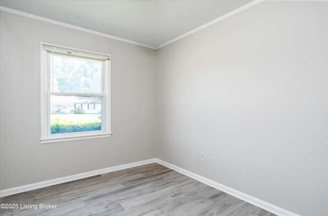 empty room with baseboards, wood finished floors, and ornamental molding