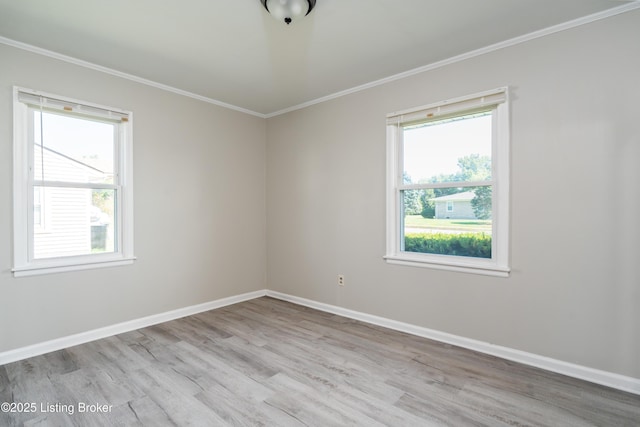 empty room with plenty of natural light, baseboards, wood finished floors, and ornamental molding