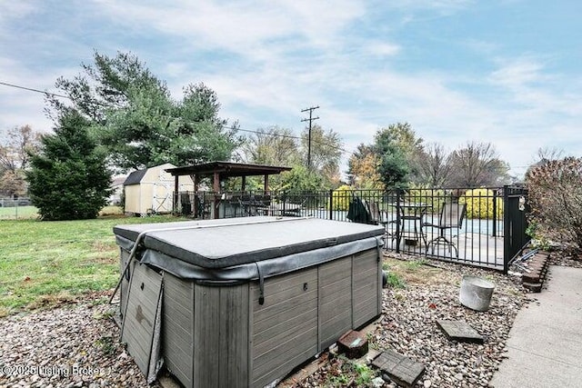 view of yard with fence, a hot tub, an outdoor structure, and a shed