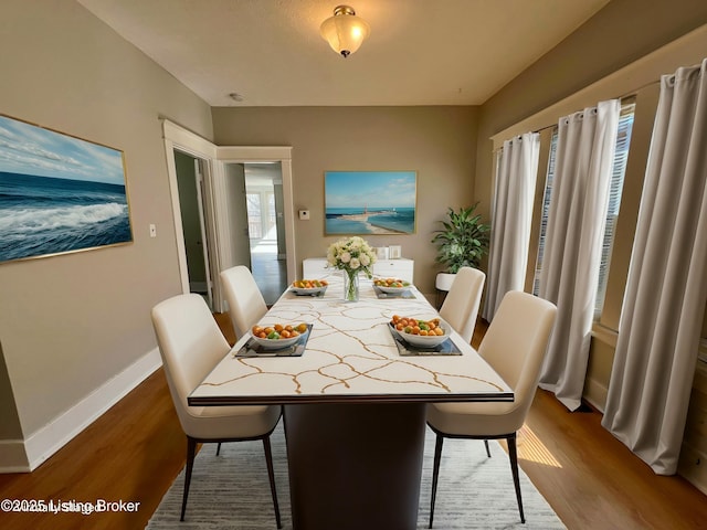 dining space with wood finished floors and baseboards