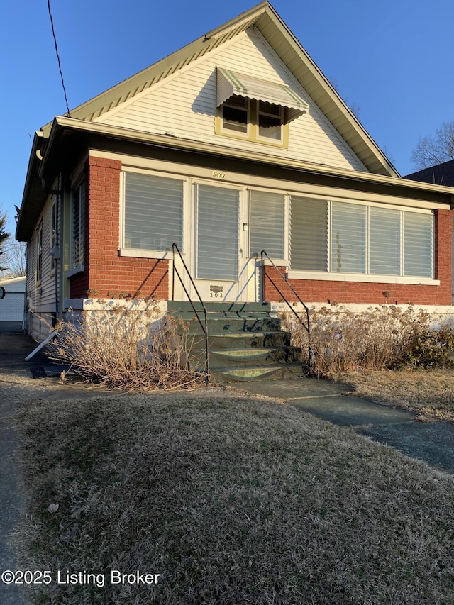 bungalow-style house with brick siding