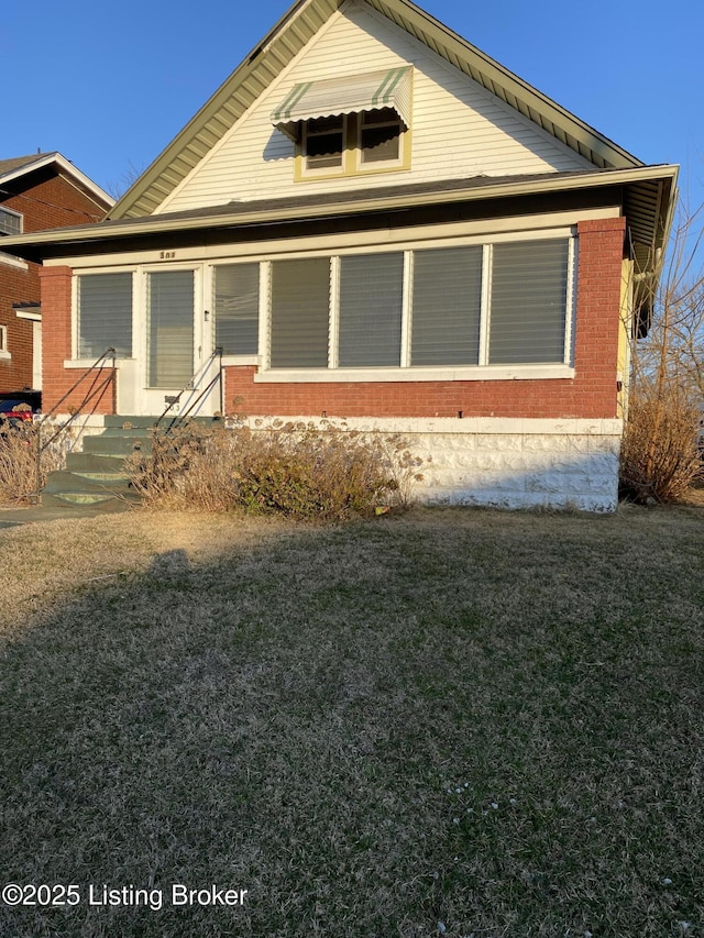 view of front of home with a front lawn and brick siding