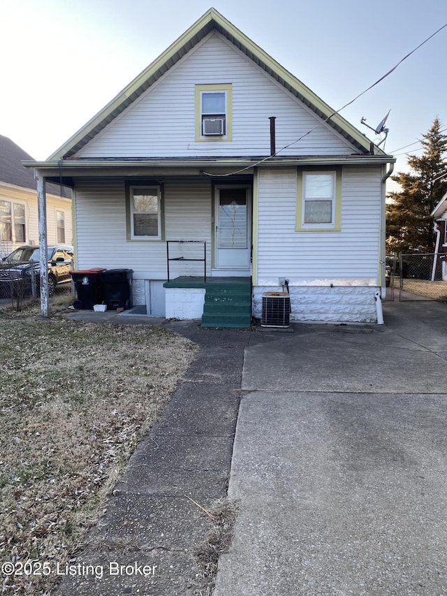 bungalow featuring central air condition unit, fence, and a porch