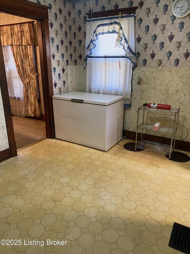 laundry room with wallpapered walls and baseboards