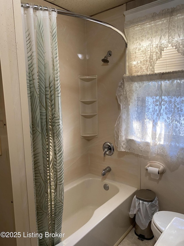 full bath featuring toilet and shower / tub combo with curtain