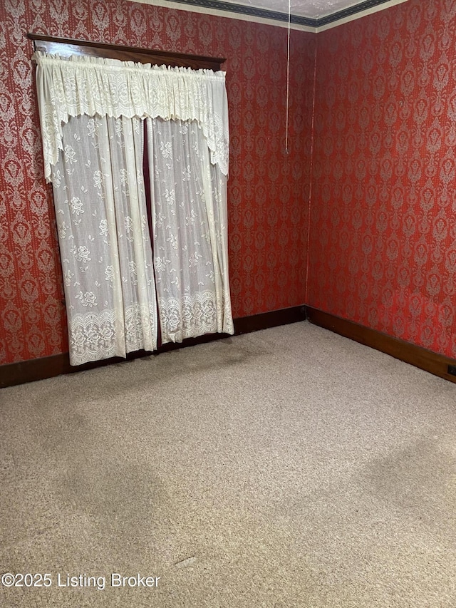 carpeted spare room with baseboards and wallpapered walls