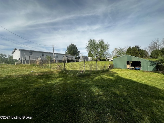 view of yard with fence and an outbuilding