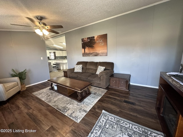 living room featuring visible vents, ornamental molding, ceiling fan, and wood finished floors