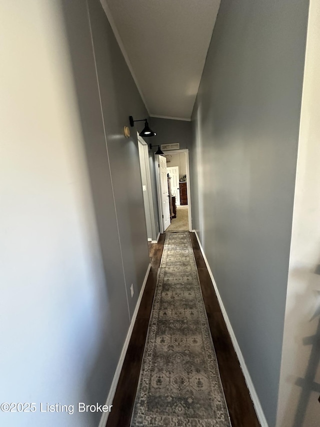 hall with ornamental molding, dark wood-style flooring, and baseboards