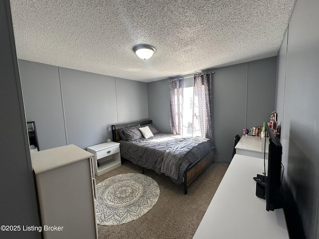 bedroom featuring a decorative wall and a textured ceiling