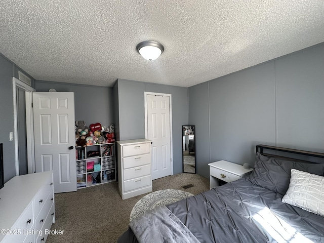 carpeted bedroom featuring a textured ceiling and a closet