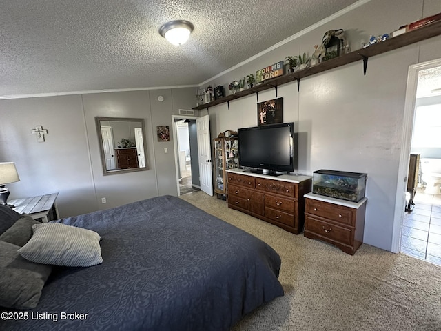 bedroom featuring a textured ceiling, ornamental molding, and light colored carpet