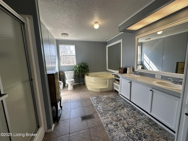 full bathroom with double vanity, a sink, a shower stall, a textured ceiling, and a bath