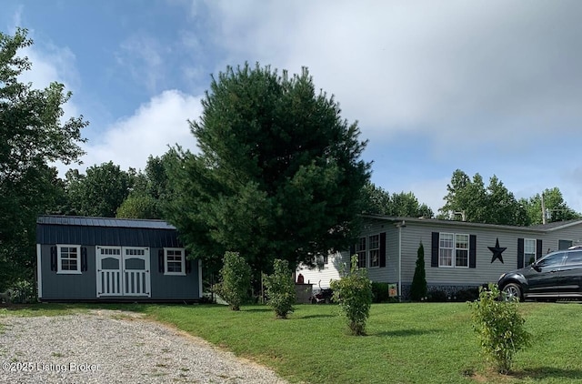 manufactured / mobile home with an outdoor structure and a front yard