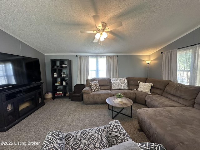 living area with lofted ceiling, a textured ceiling, carpet floors, a fireplace, and ornamental molding