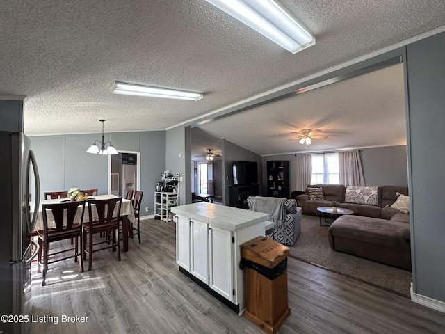 kitchen featuring lofted ceiling, white cabinetry, dark wood-type flooring, and freestanding refrigerator