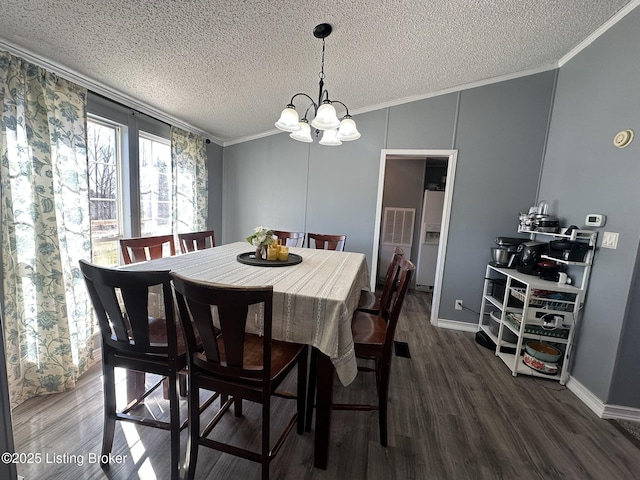 dining area with dark wood-style flooring, crown molding, an inviting chandelier, a textured ceiling, and baseboards