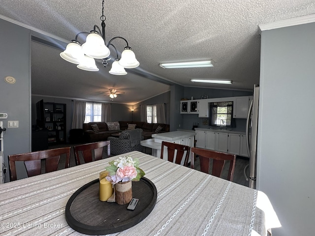 dining area with vaulted ceiling, an inviting chandelier, dark wood-style floors, and a healthy amount of sunlight