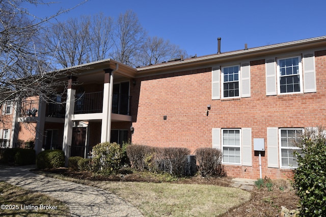 exterior space with brick siding and a balcony