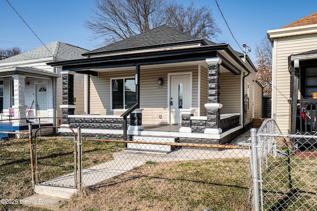 view of front of home featuring a fenced front yard, a porch, roof with shingles, and a gate