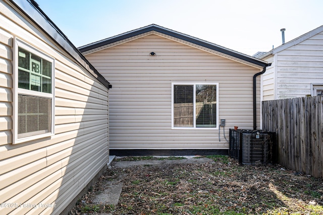 view of home's exterior with central AC unit and fence