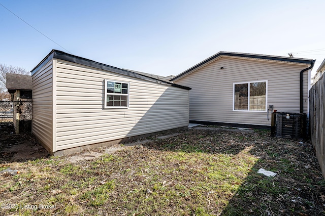 back of house featuring central air condition unit and fence