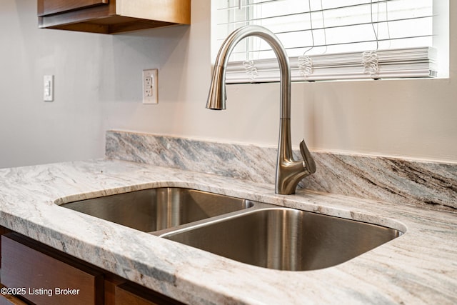 details featuring light stone countertops and a sink