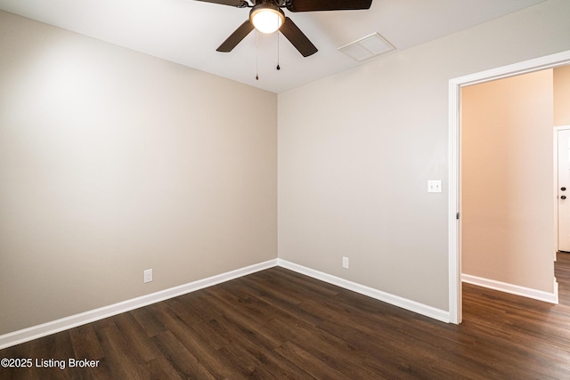 empty room with dark wood-style floors, visible vents, and baseboards