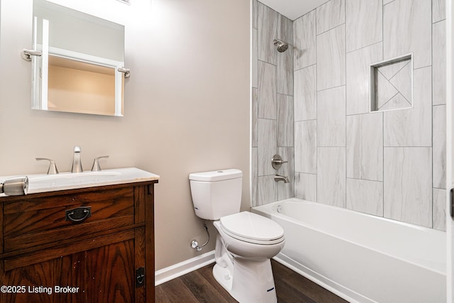 bathroom featuring baseboards, toilet, shower / bathtub combination, wood finished floors, and vanity