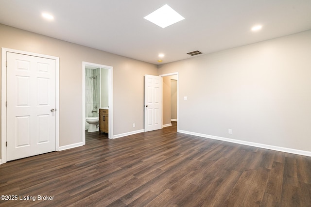 spare room with visible vents, recessed lighting, a skylight, baseboards, and dark wood-style flooring