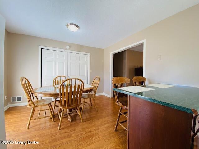 dining room with visible vents, baseboards, and light wood-style floors