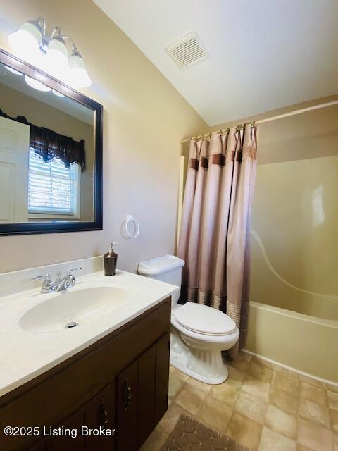 full bathroom featuring visible vents, shower / bath combo with shower curtain, toilet, lofted ceiling, and vanity