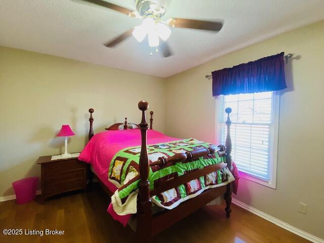 bedroom featuring a ceiling fan, baseboards, and wood finished floors