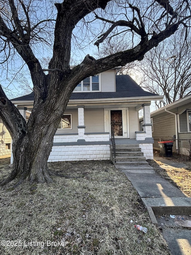 view of front of property featuring roof with shingles and a porch