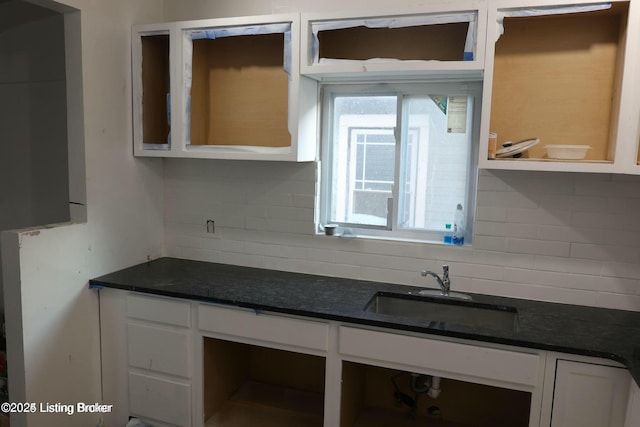 kitchen with a sink, decorative backsplash, and white cabinetry