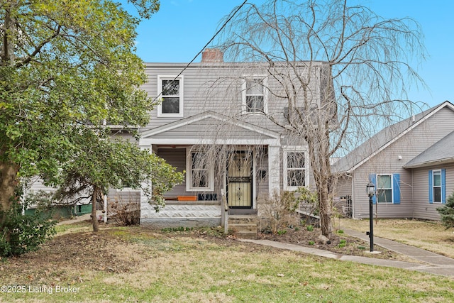 view of front of home with a front yard and a chimney