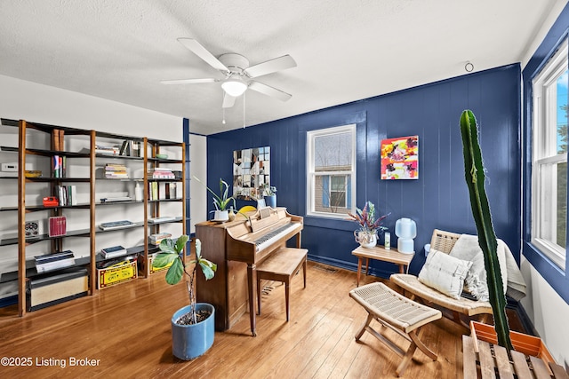 home office with a textured ceiling, ceiling fan, and hardwood / wood-style flooring