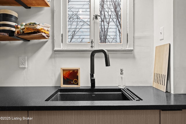 details featuring dark countertops, open shelves, and a sink