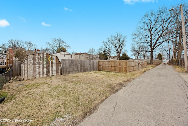 view of yard featuring an outbuilding, a shed, and a fenced backyard