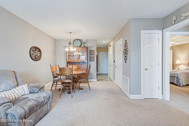 dining room featuring carpet flooring, baseboards, visible vents, and a chandelier