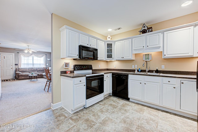 kitchen featuring visible vents, a sink, black appliances, white cabinets, and dark countertops