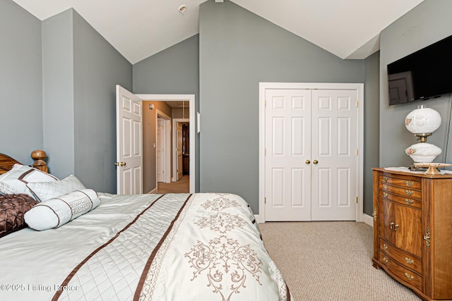 bedroom featuring a closet, light colored carpet, and vaulted ceiling