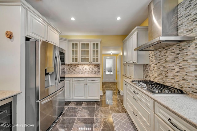 kitchen featuring tasteful backsplash, wall chimney range hood, beverage cooler, recessed lighting, and appliances with stainless steel finishes